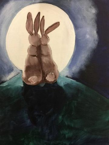 Two bunnies sitting on a hill staring at the moon