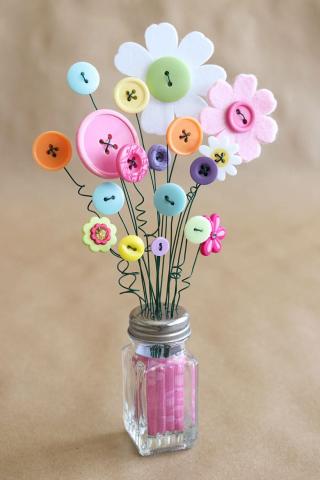 Image depicting a salt shaker with button flowers inserted into the shaker's holes.