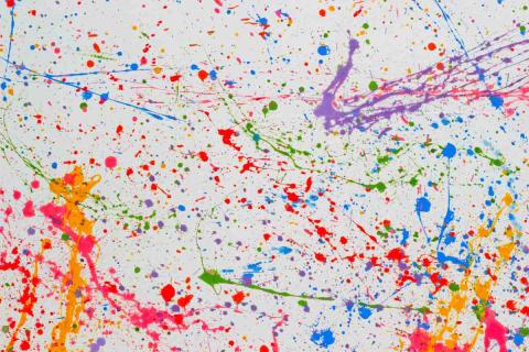 Picture of a white paper with colorful paint splattered all over it.