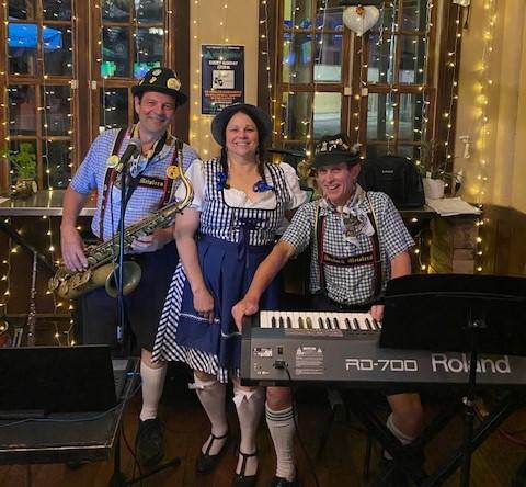 2 male and 1 female dressed in blue and white german clothing