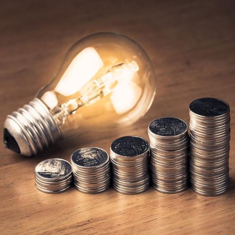 LIght bulb ona table with stacks of quarters next to it