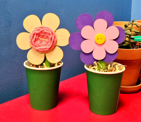 picture of yarn wrapped wooden flowers in paper cup