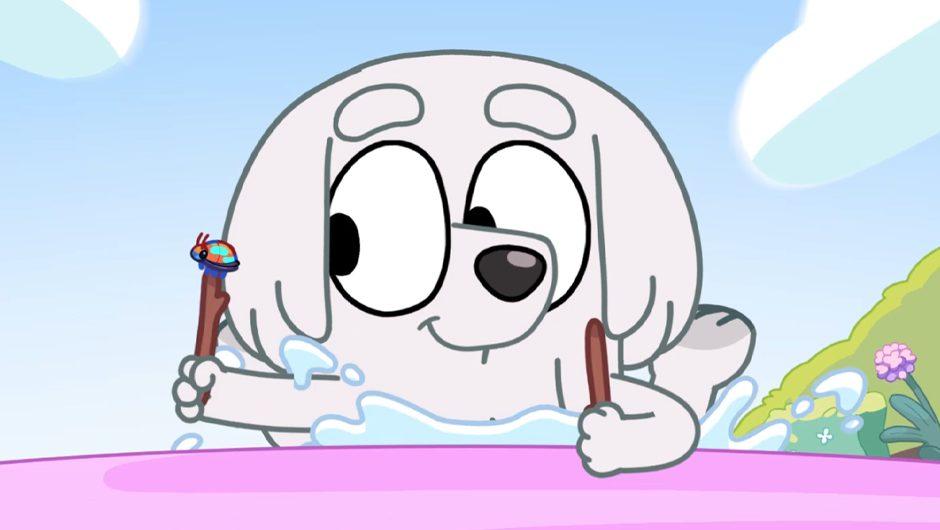 Picture of an episode from Bluey with white dog holding two sticks with bugs on them