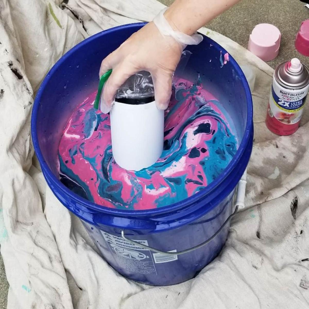 An image depicting a metal coffee cup being dipped.