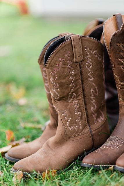 A set of brown cowboy boots on green grass